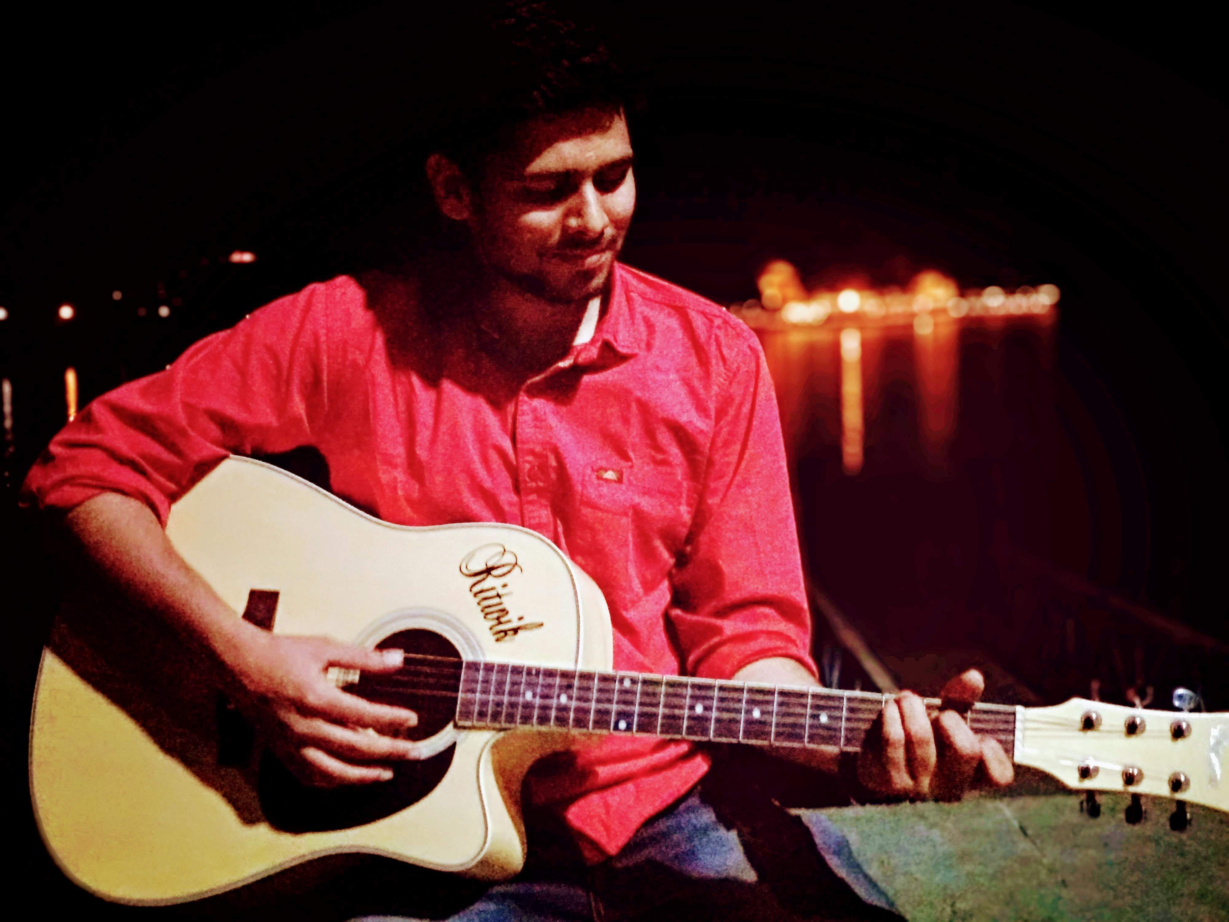 Ritwik Joshi playing guitar at Lake Fatehsagar